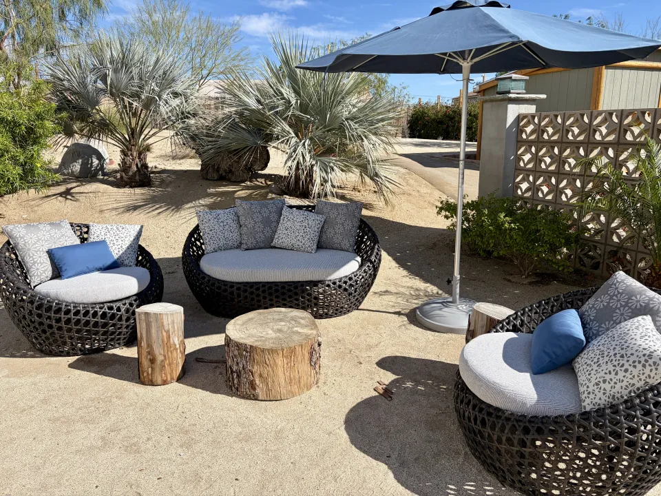 Curved outdoor wicker seating with grey and blue cushions